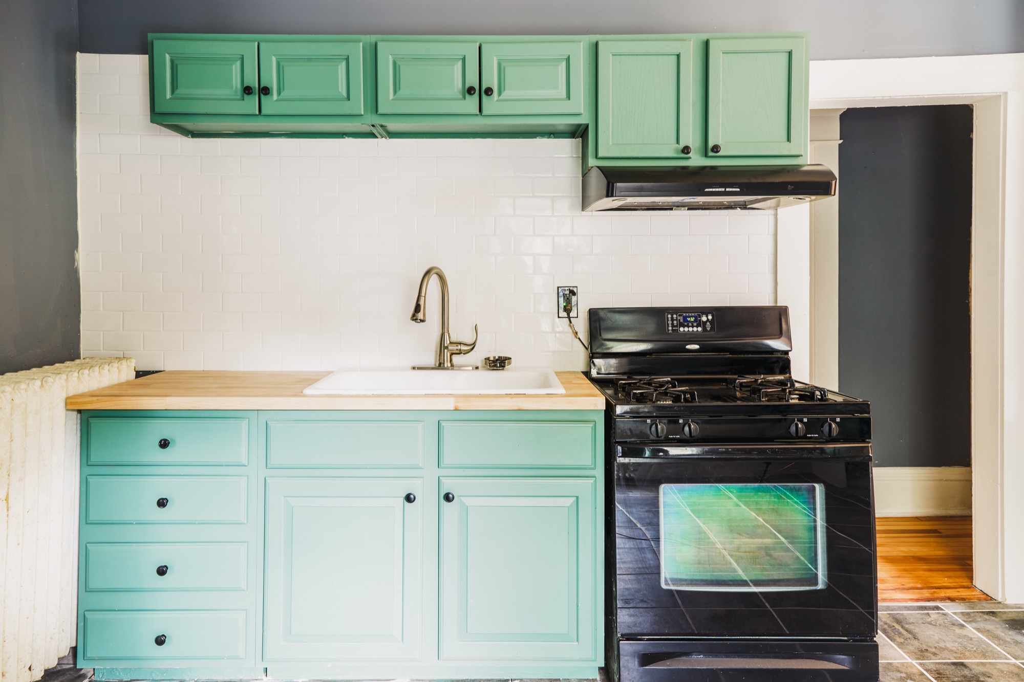 Renovated kitchen with deep green cabinetry, the signature of a Verus Praedium property