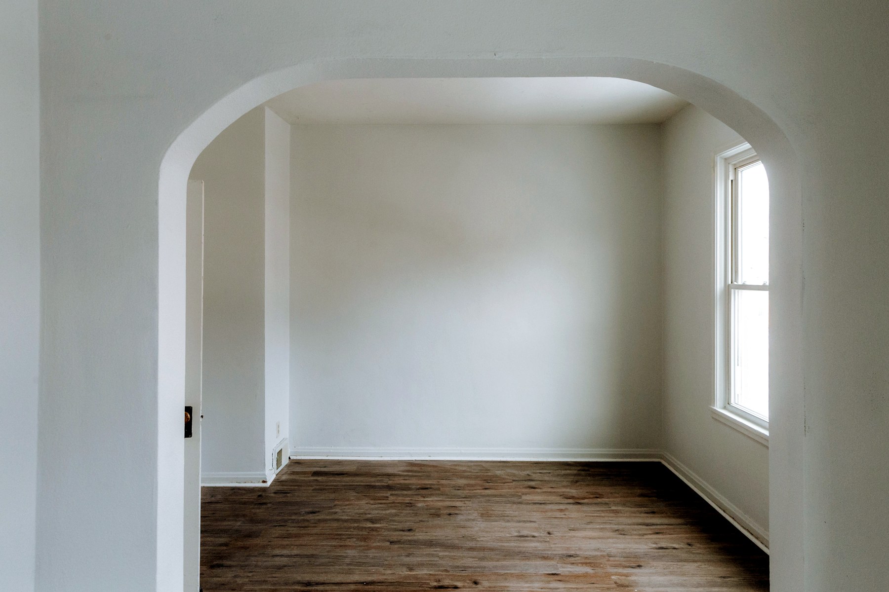 A bright room framed by an original arched doorway