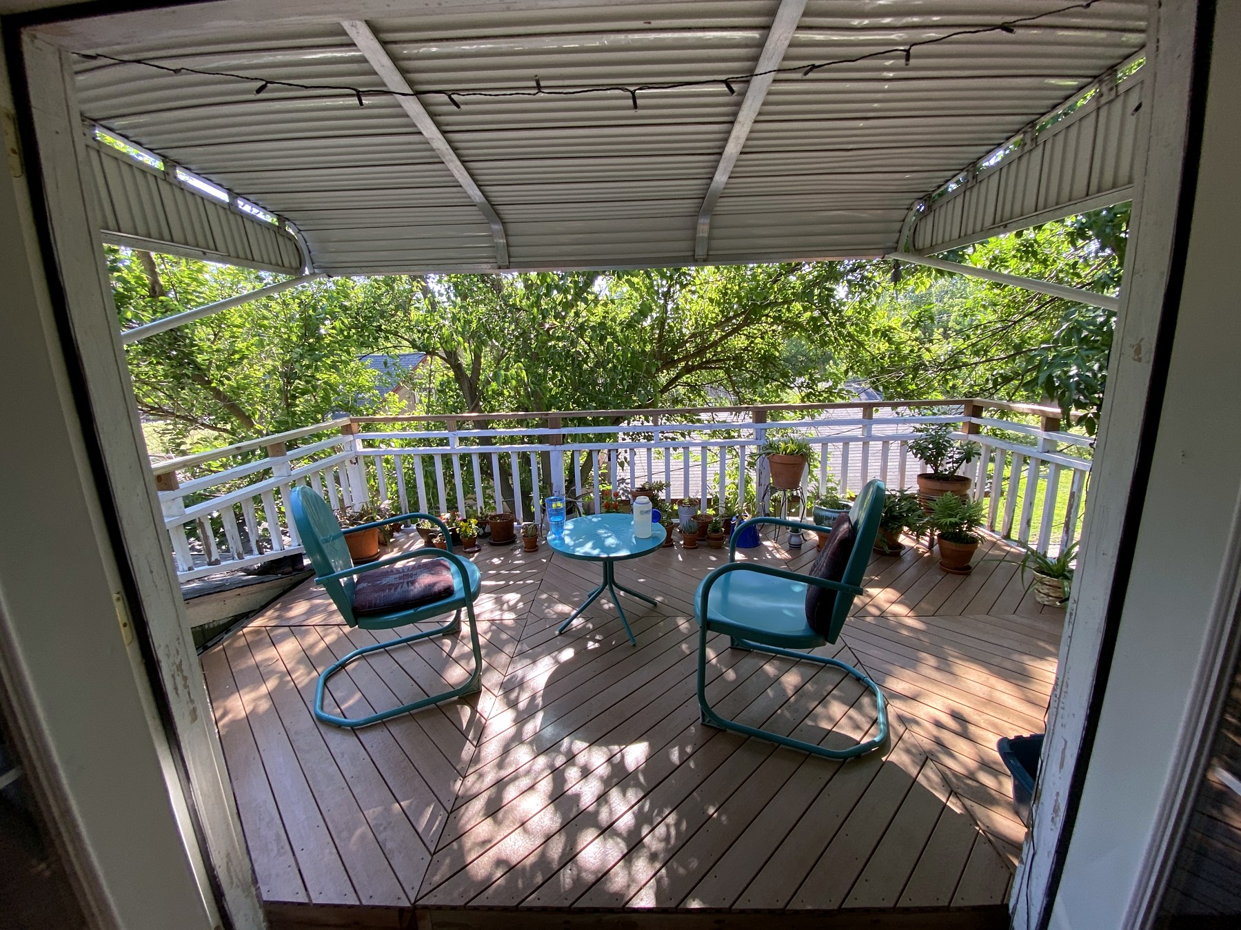 A covered deck with outdoor seating overlooking the backyard
