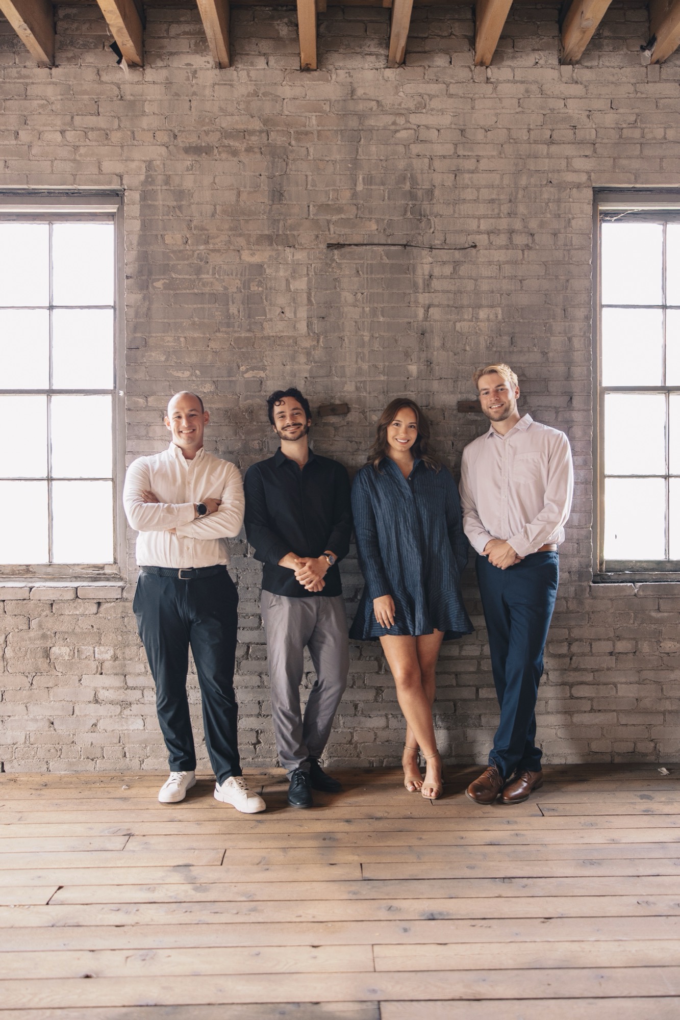 The Revolution Realty Group brokerage team, photographed together against a brick wall